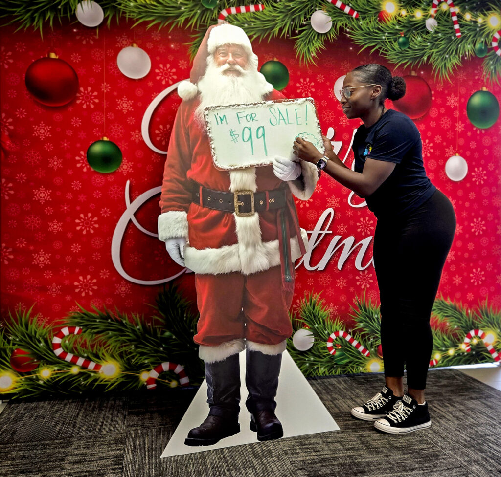 A picture showcasing a life-sized stand up of Santa.
